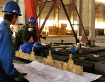 鋼廠鑄造車間工人用永磁起重器起吊鋼板